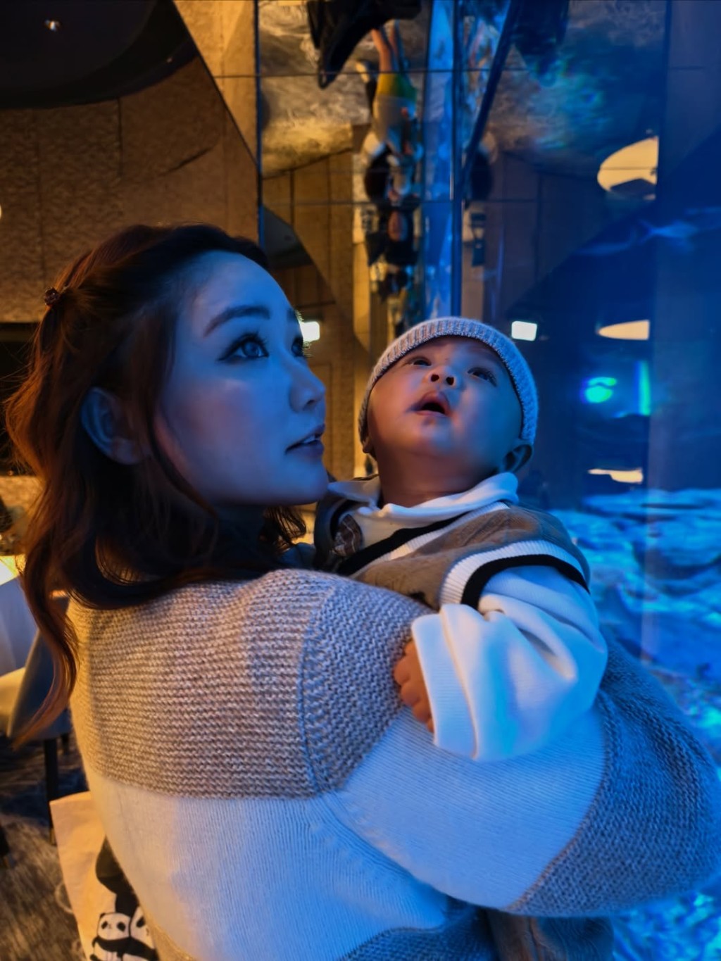 程美段抱着兒子,房間內有大玻璃窗可觀賞魚缸,她大讚體驗與服務一流。