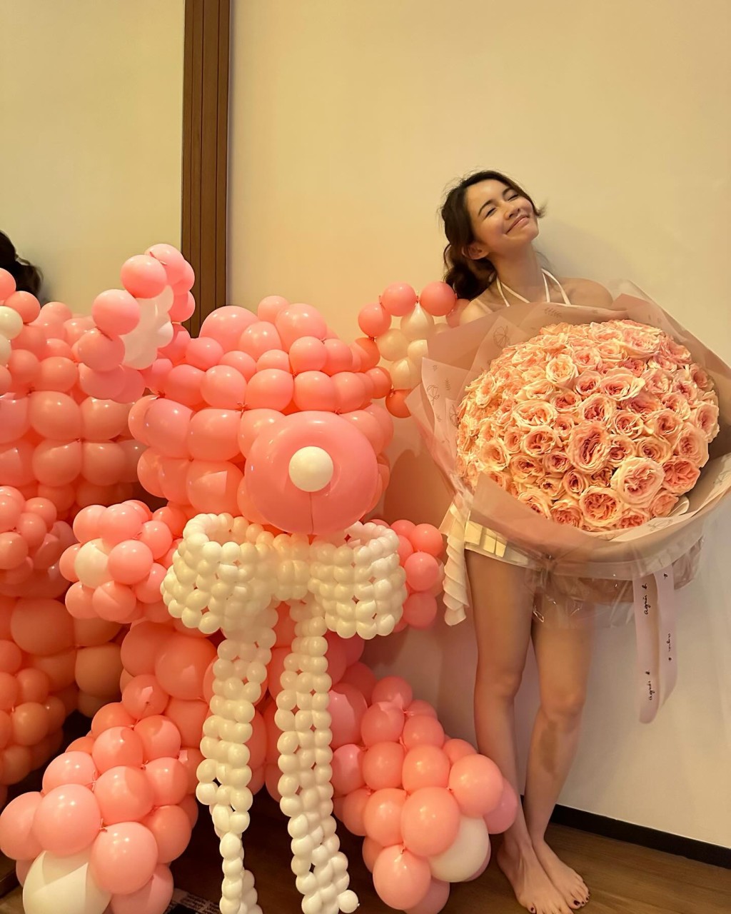 她曾手捧大量粉紅玫瑰,面露滿足笑容,並展示鎖骨與長腿。